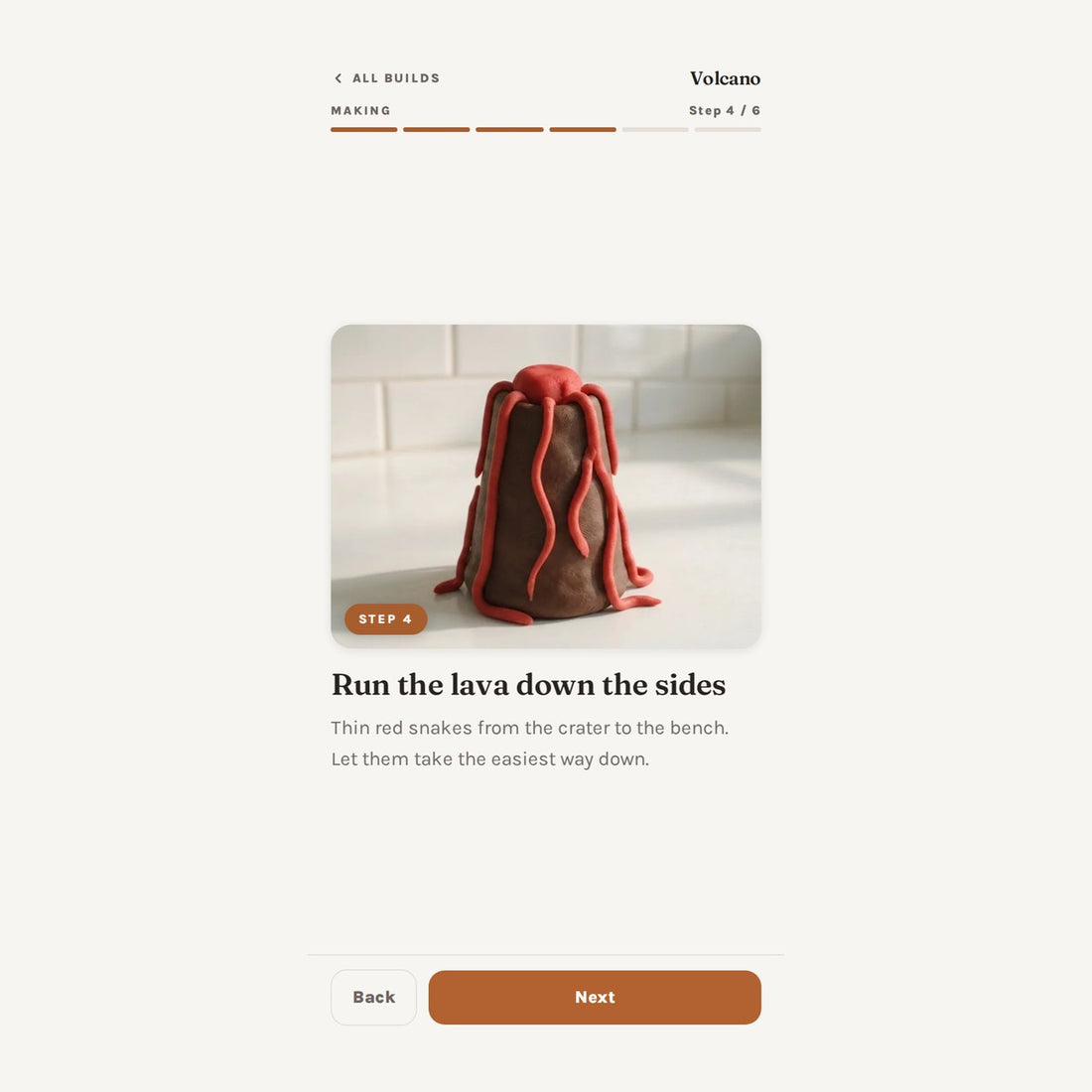 One step of the volcano build, with a full-width photo of the play dough and a single line of instruction